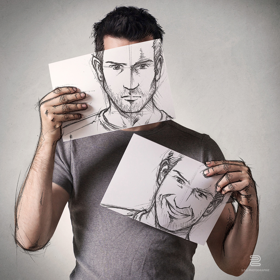 Artist holds a drawn self-portrait before his face