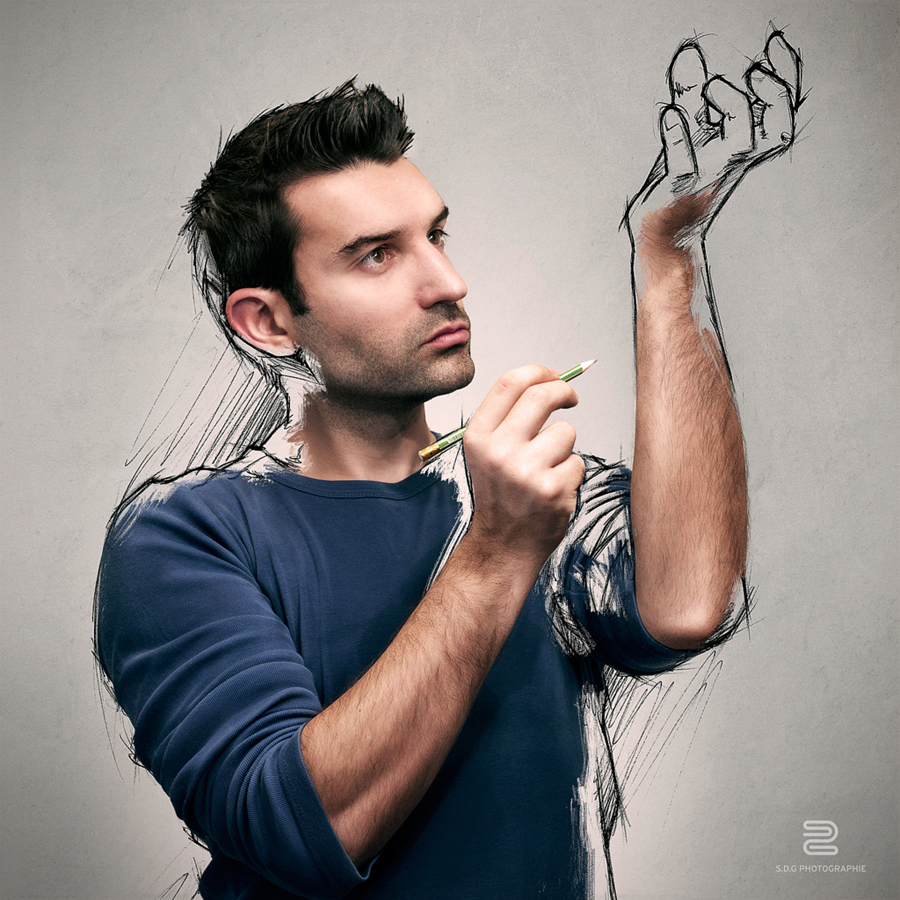 Artist sketches a small figure above his outstretched hand