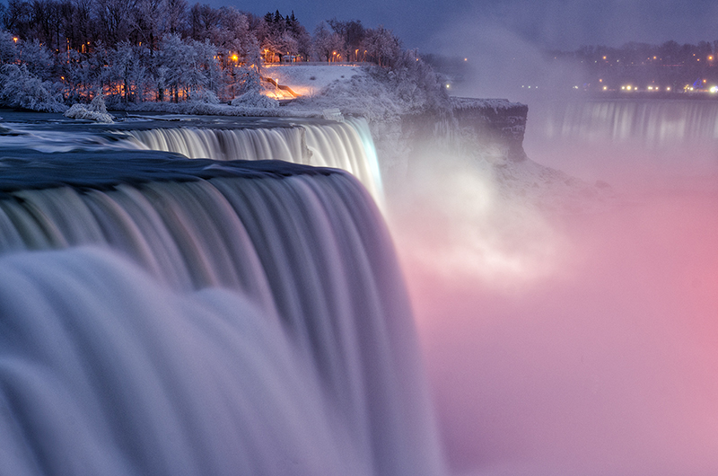 Niagara Falls lit purple at dusk