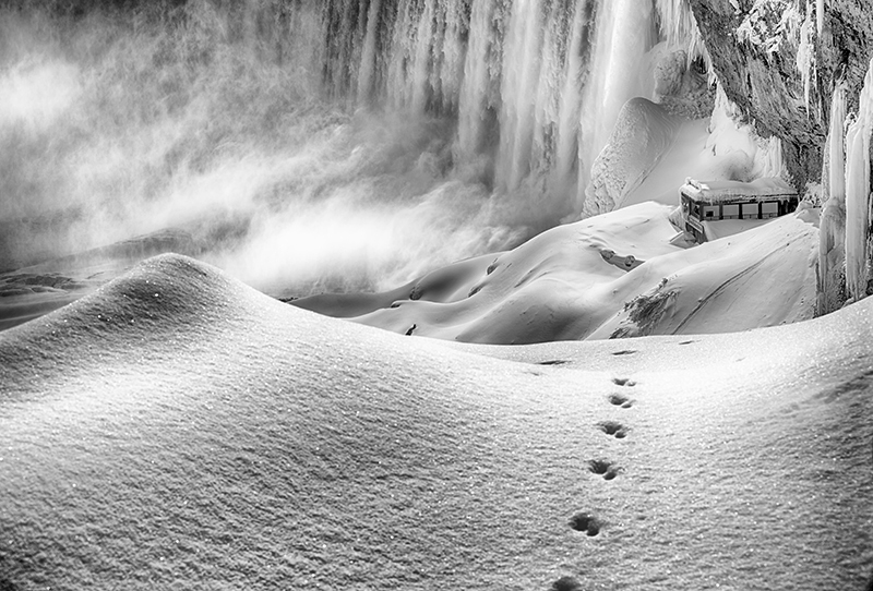 Snowy path near a frozen waterfall