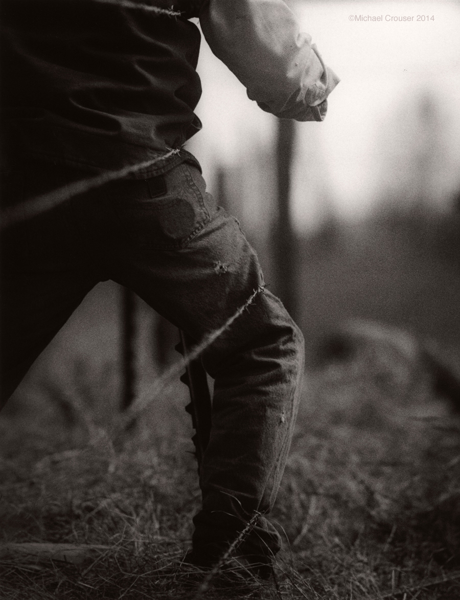 Ranch worker and barbed-wire fence in black and white