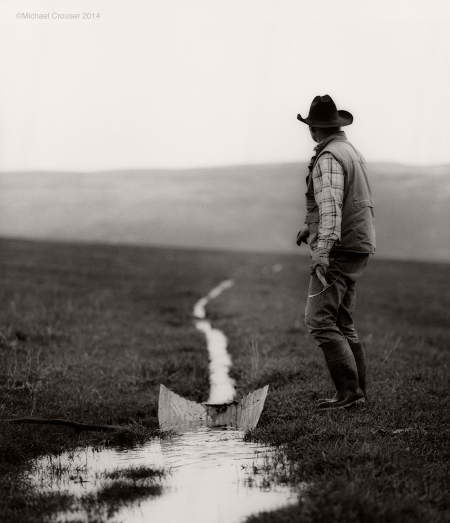 Ranch worker carrying an irrigation tool