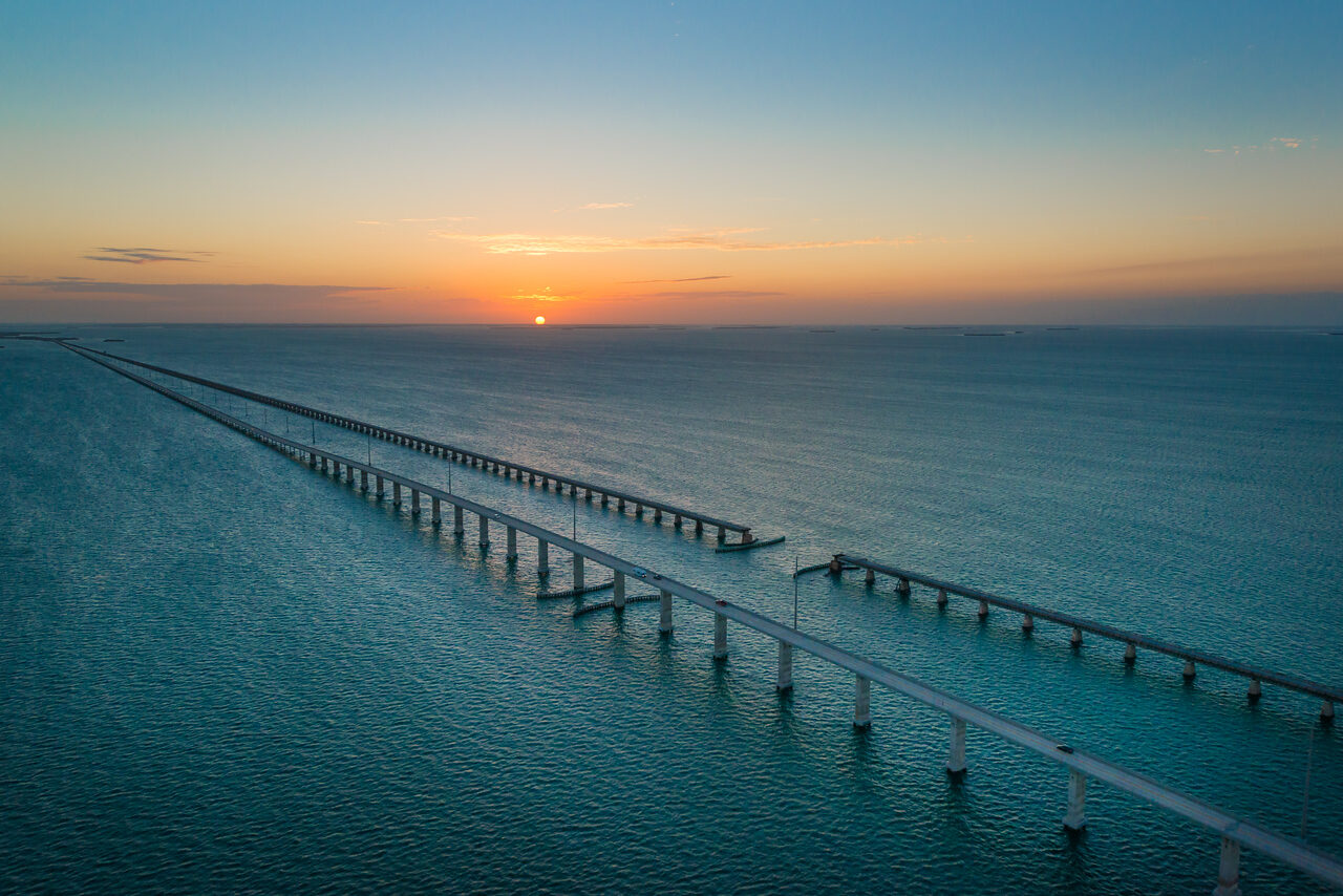 Aerial view of the Seven Mile Bridge in the Florida Keys at sunset over smooth turquoise water
