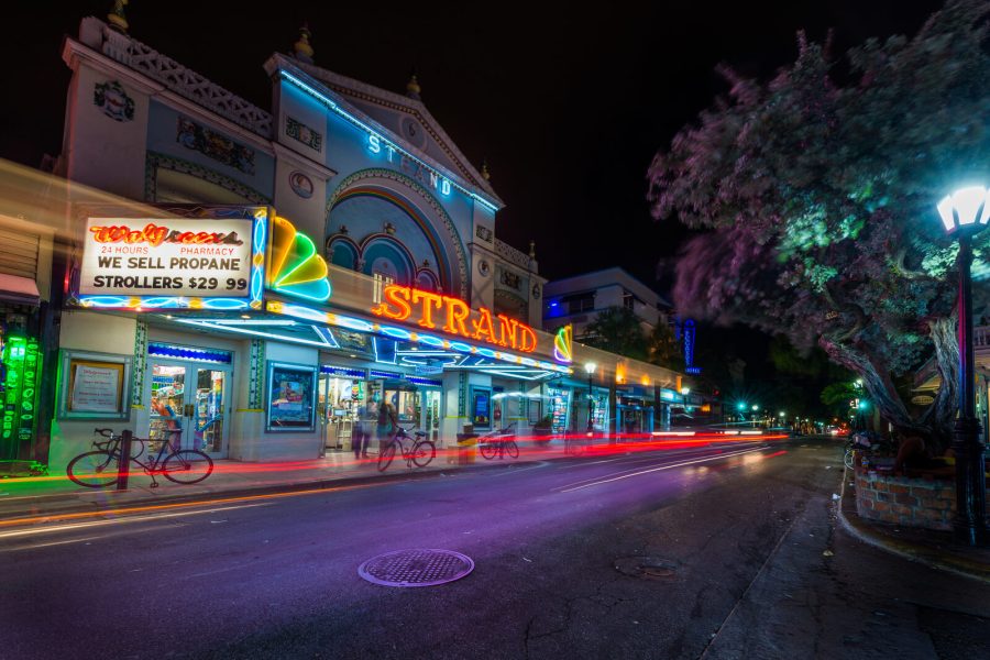 Light trails from passing cars in front of the Strand theater on a Key West street at night