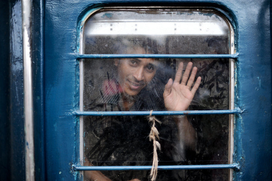 Passenger waving through barred train window
