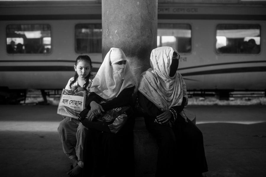 Three women seated at a station