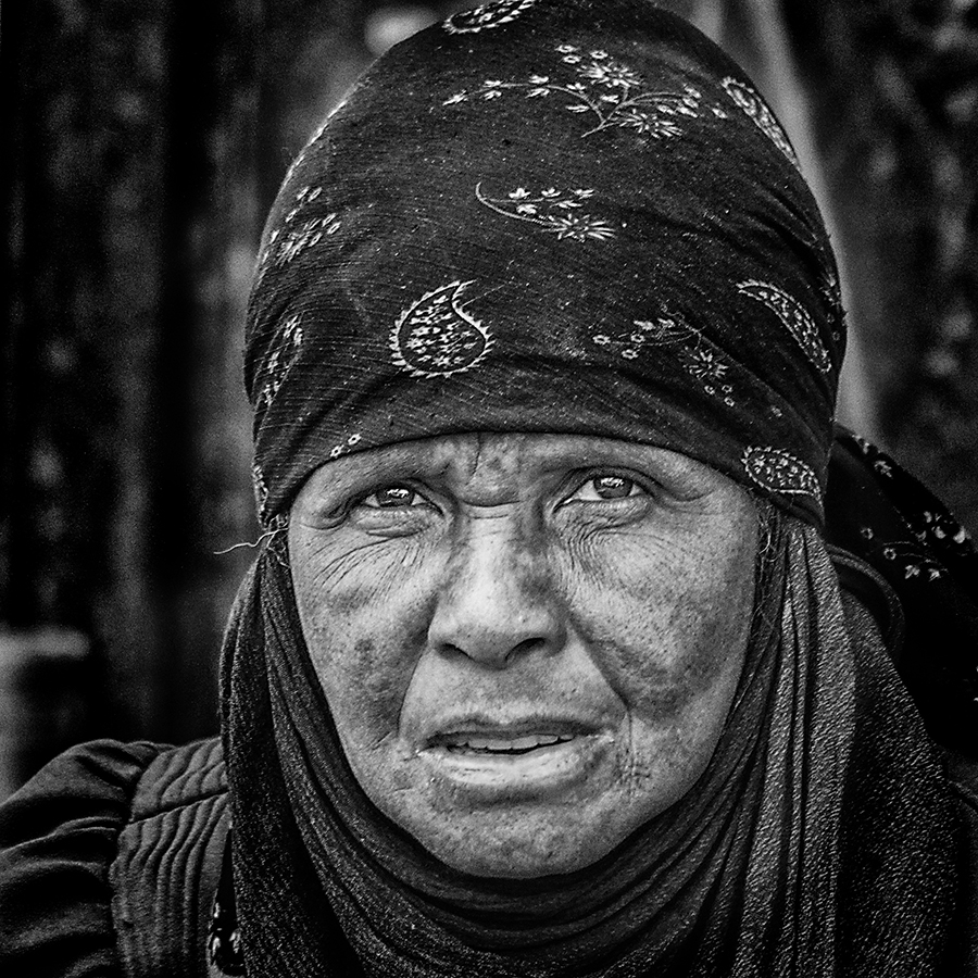 Black-and-white portrait of a woman in a patterned headscarf