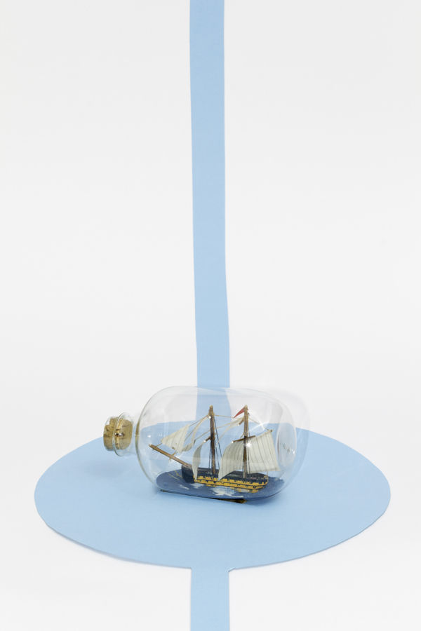 Small boat on a blue paper puddle