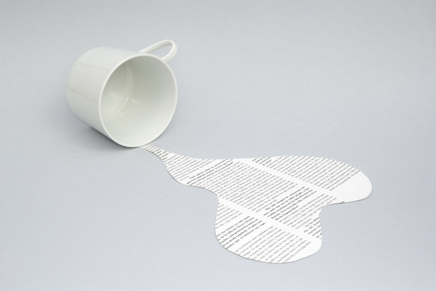 Cup tipped beside a paper-shaped spill