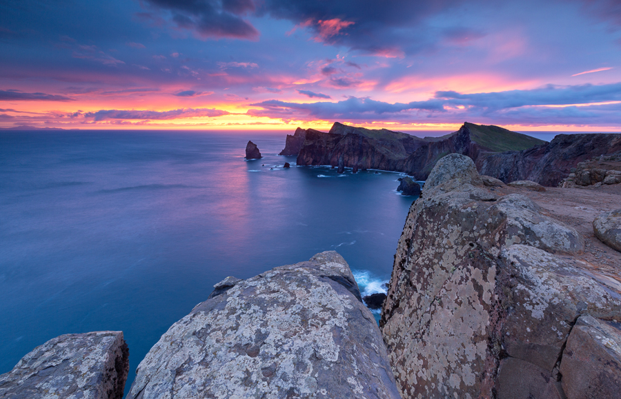 Rocky sea cliff beneath a pink sky
