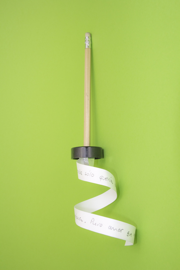 Pencil cutting into a curl of paper on green