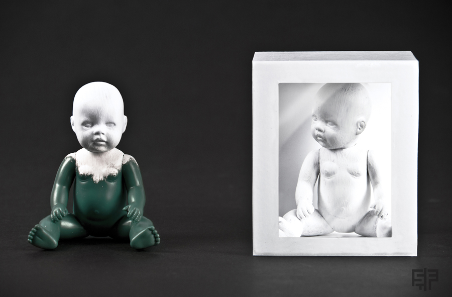 Baby beside a framed portrait in a surreal composition