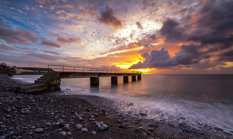 Pier beneath a glowing sunset sky
