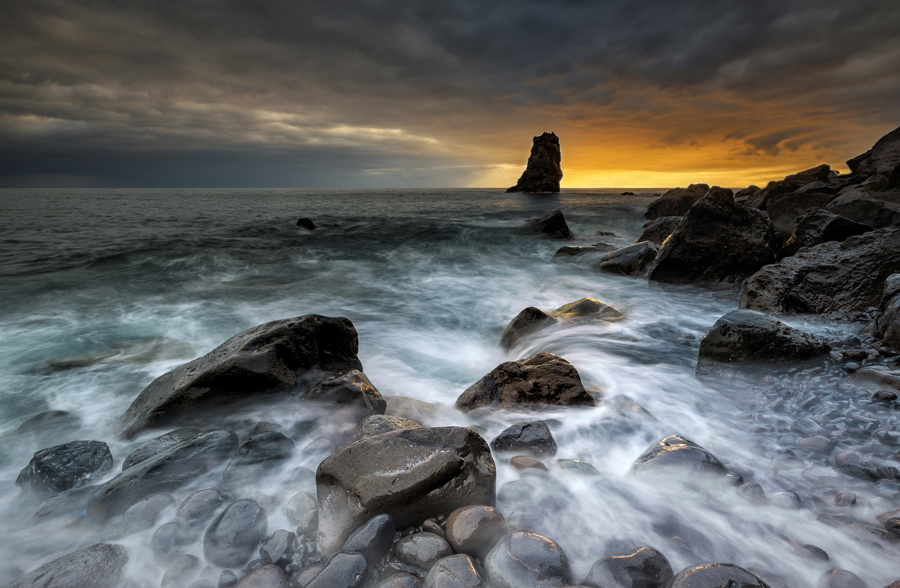 Rocky coastline beneath a cloudy sky