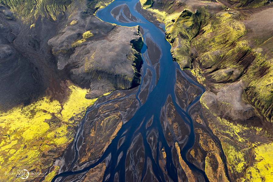 Blue river dividing yellow-green slopes