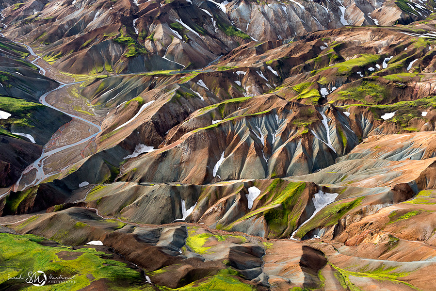 Green valleys etched through colorful highlands