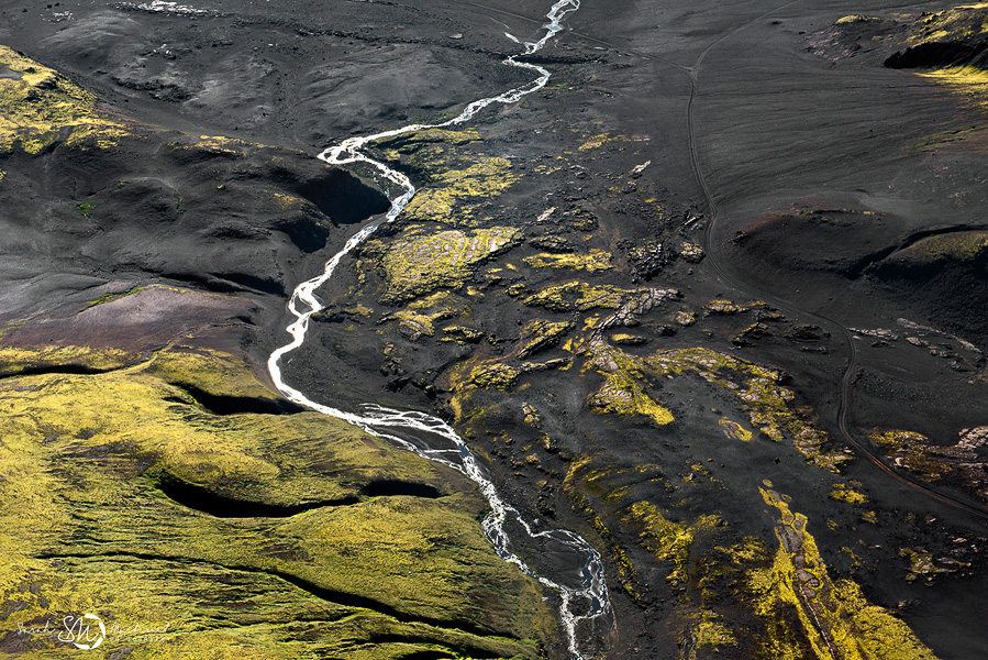 White river winding through dark volcanic terrain