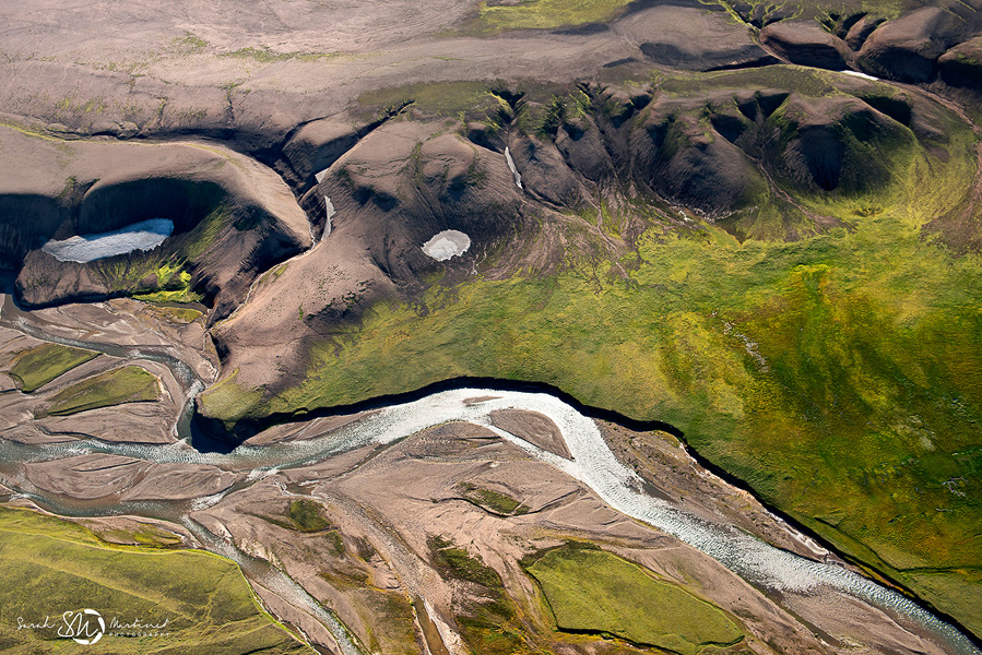 Aerial view of river channels through mossy valley