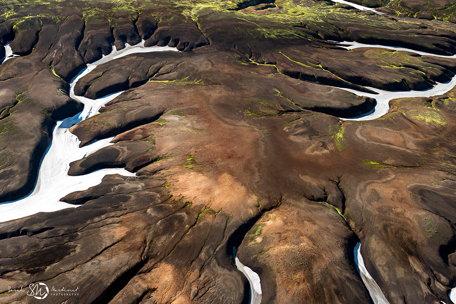 Aerial view of snow patches on volcanic hills