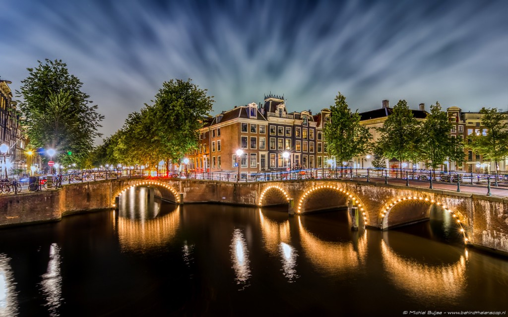 Amsterdam canal bridge lit at night