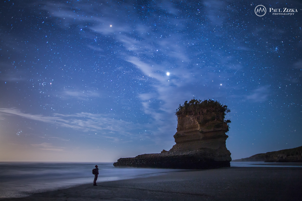 Lone figure on a beach under stars