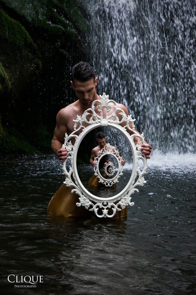 Figure holding a circular object beside water