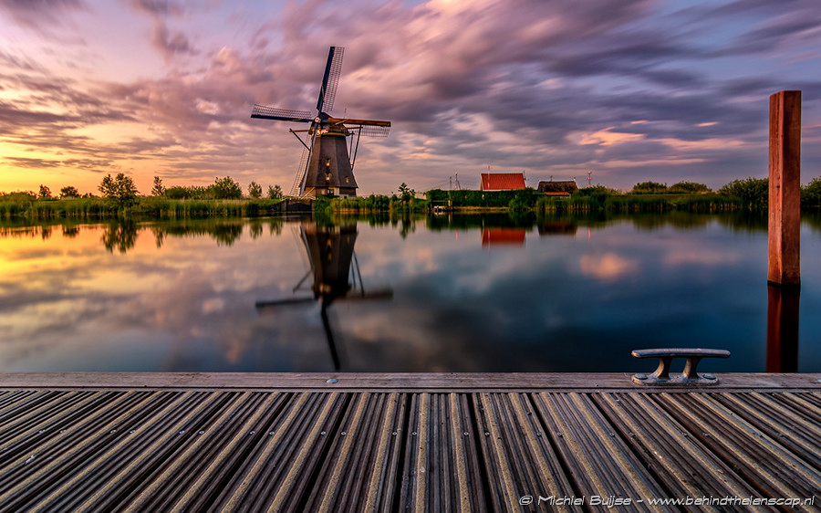 Windmill reflected beneath a colorful sky