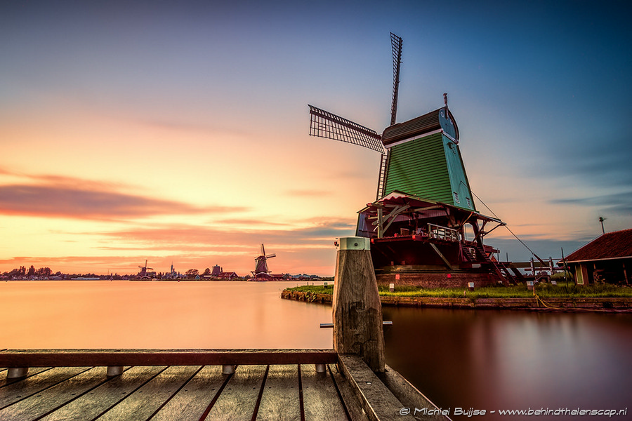 Windmill reflected in water at dusk