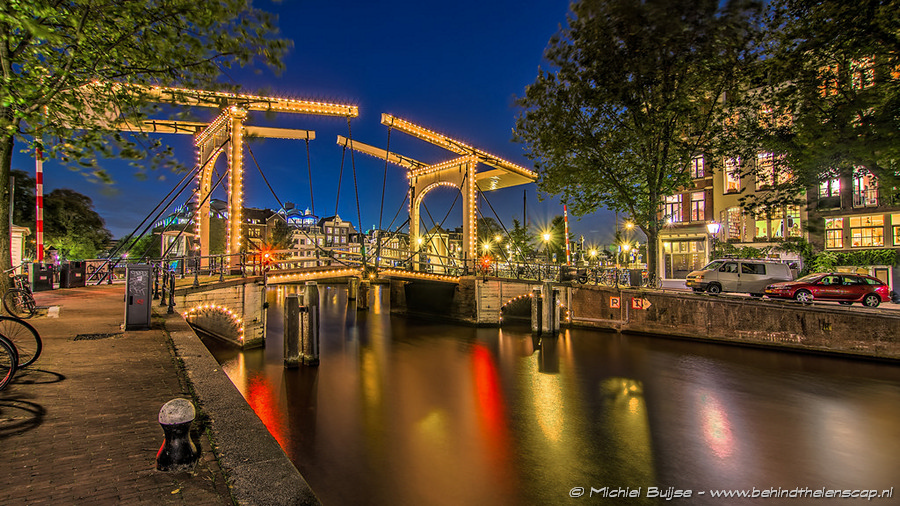 Lit canal bridge and boats at blue hour
