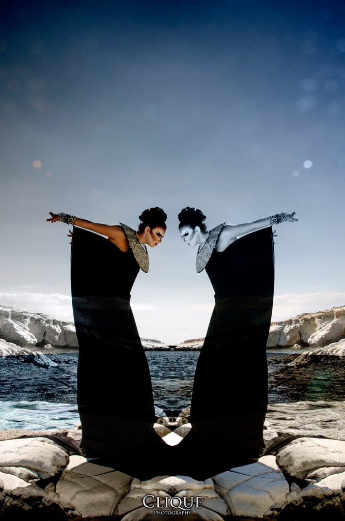 Two figures holding a cloth by the shoreline