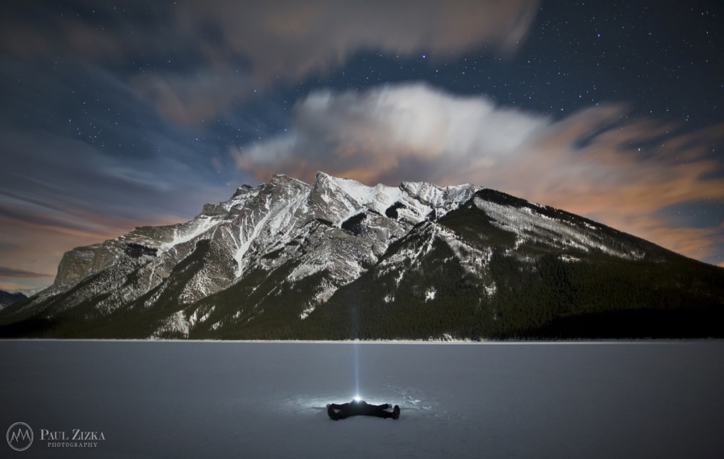 Figure in a lake beneath a snow-covered mountain