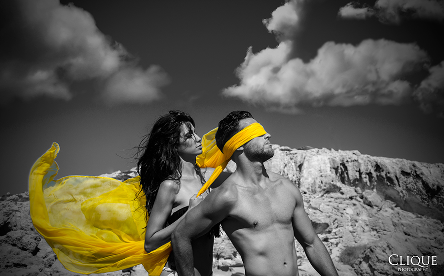 Two figures in a dramatic grayscale scene with yellow cloth