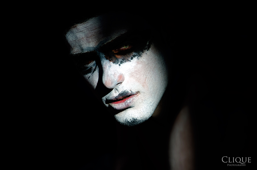 Shadowed portrait of a figure in a dark hat