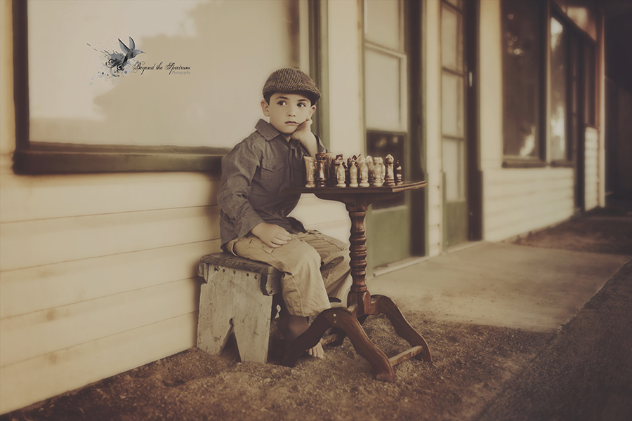 Child seated on a porch with a toy