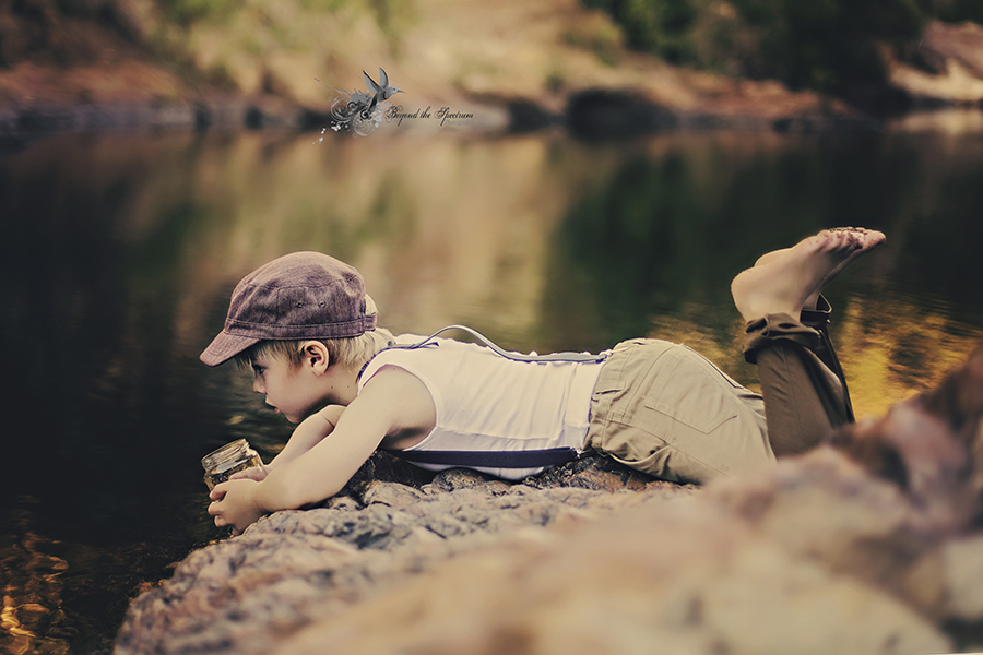 Child lying beside a stream