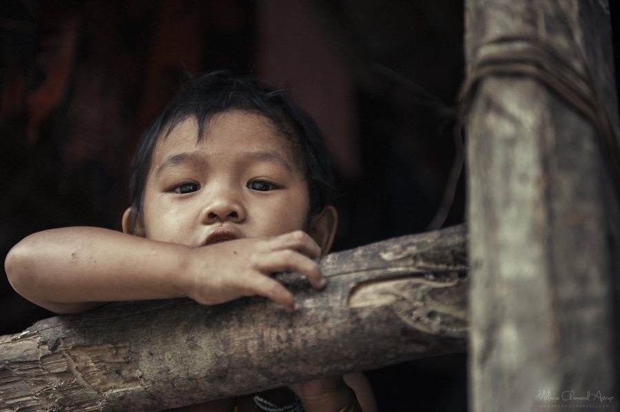 Child resting arms on a wooden surface