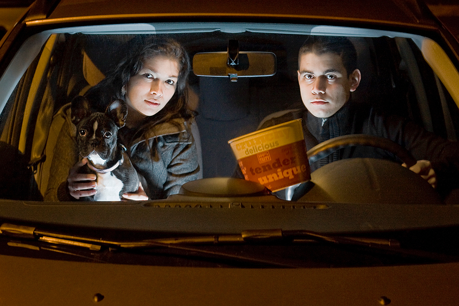 Two people looking forward in a car at night