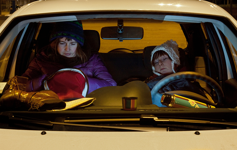 Two people sitting in a yellow-lit car