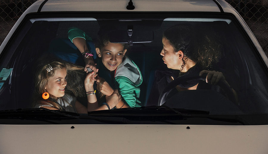 Three people laughing inside a car