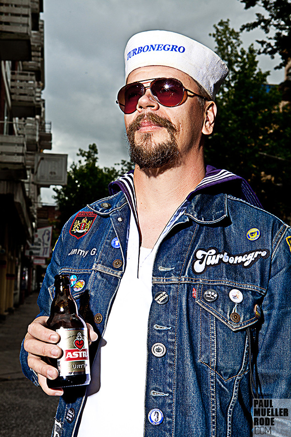 Man in denim vest holding a beer