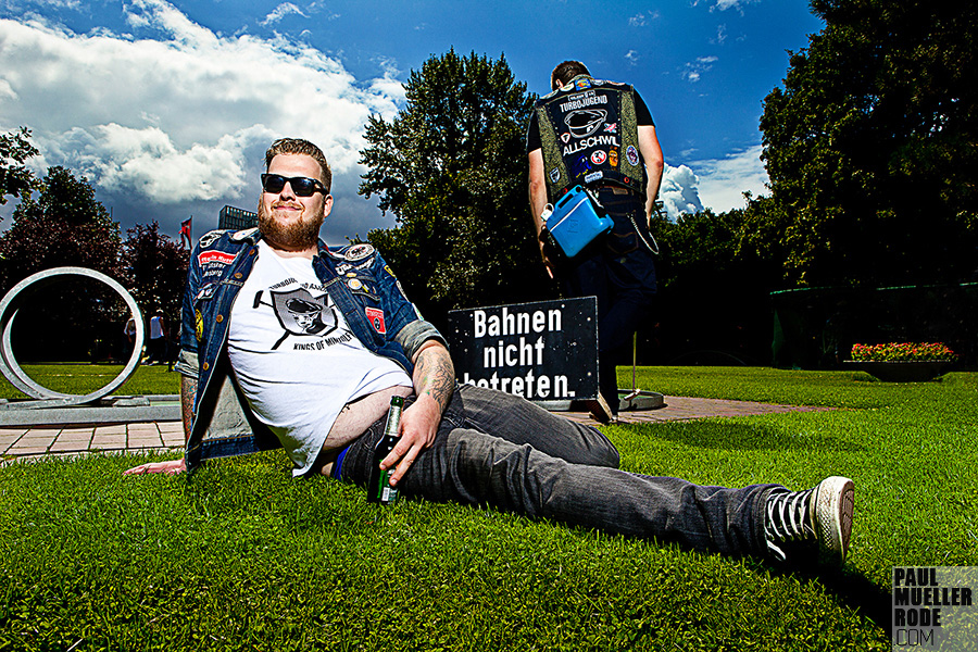 Fan sitting on grass in denim vest