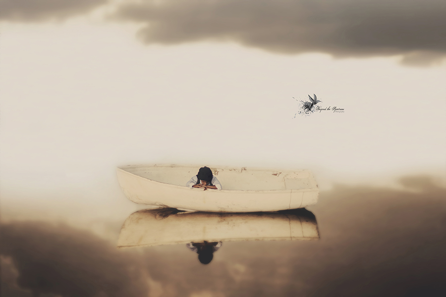 Child in a small boat in a dreamy seascape
