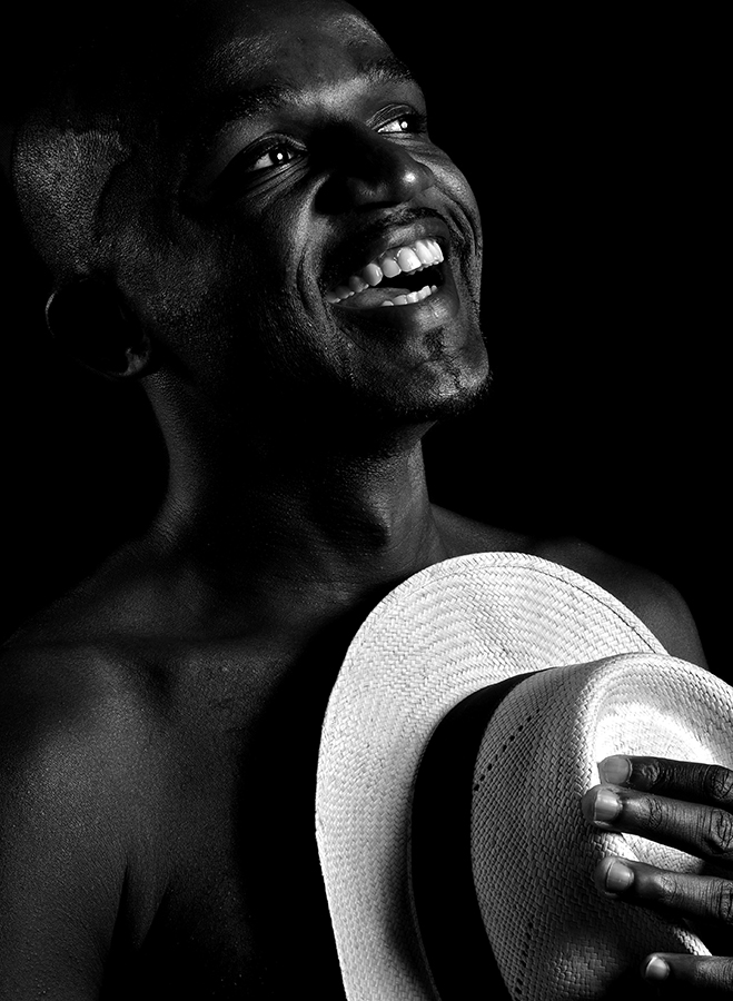 Smiling person holding a light-colored hat
