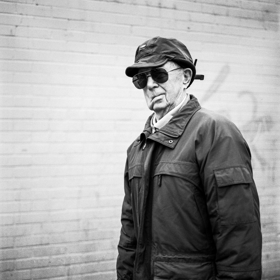 Person in a hat and scarf against a wall