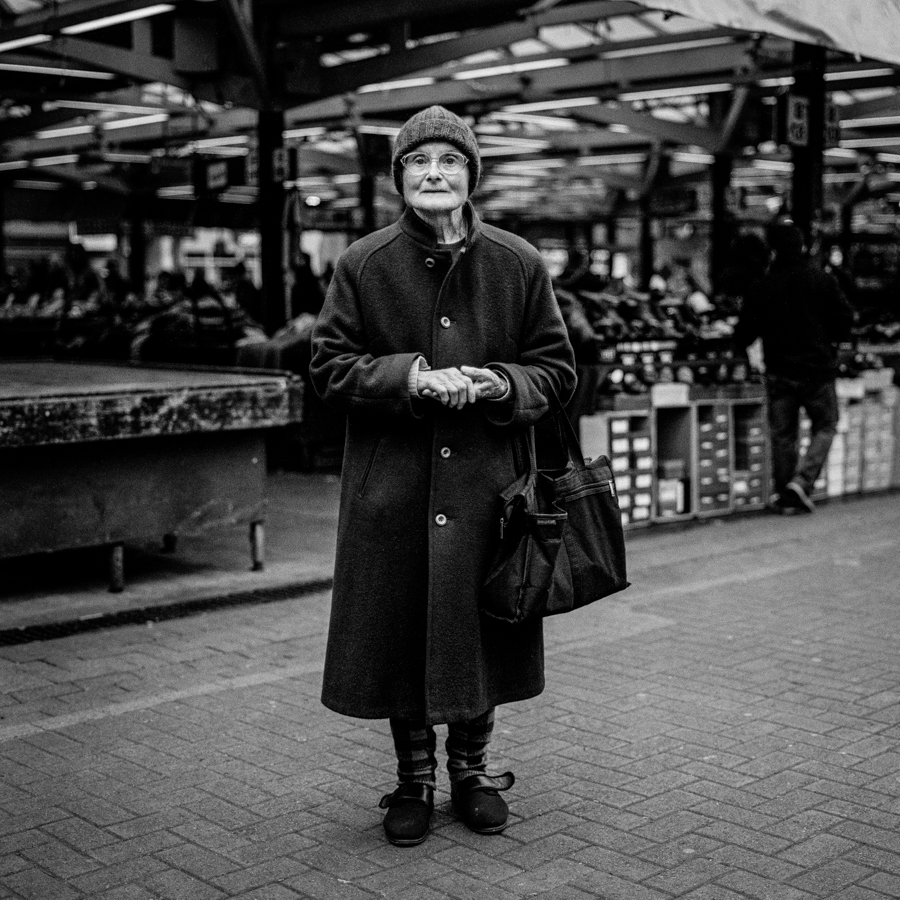 Older woman standing by a street market