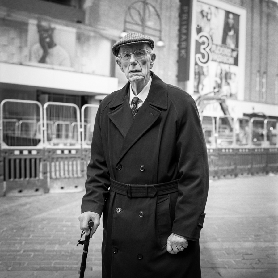 Older man with cane in a city square