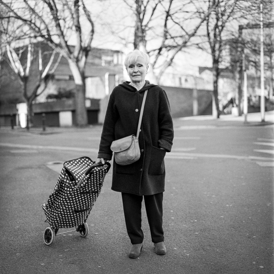 Older man standing beside a shopping trolley
