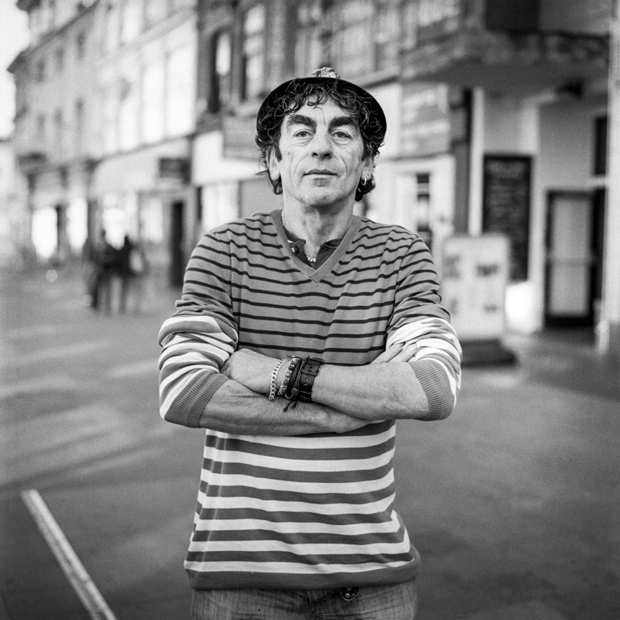 Young man in striped shirt on a city street