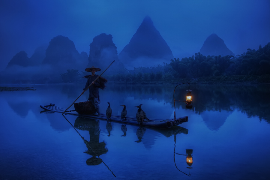 Cormorant fisherman at dusk on a river
