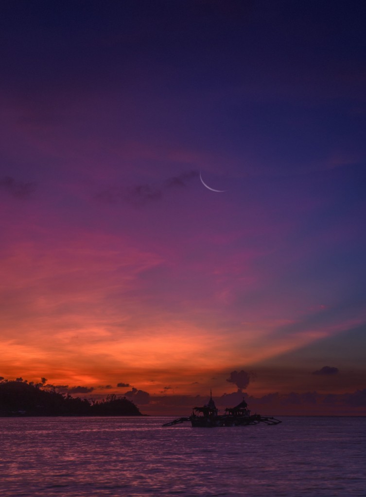 Boat beneath a purple and orange twilight sky